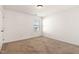 Bright bedroom with neutral carpet and walls, illuminated by a window and ceiling light at 2000 Muddy Creek Ct, Raleigh, NC 27610