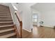 Entryway featuring a staircase with carpeted treads and wood railing and a view into adjacent living areas at 2000 Muddy Creek Ct, Raleigh, NC 27610