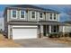 Inviting two-story home featuring a two-car garage and charming covered porch with decorative columns at 2000 Muddy Creek Ct, Raleigh, NC 27610