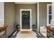 Close-up of a welcoming front door with a wreath, potted plants, and brick detailing at 2000 Muddy Creek Ct, Raleigh, NC 27610