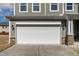 Attached two-car garage with a white door, brick accents, and stylish exterior lighting at 2000 Muddy Creek Ct, Raleigh, NC 27610