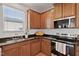 Corner kitchen with natural light and wood cabinets with granite counters offers a delightful cooking experience at 2000 Muddy Creek Ct, Raleigh, NC 27610