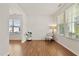 Sunlit living room with hardwood floors, white walls, and three large windows with blinds for natural light at 2000 Muddy Creek Ct, Raleigh, NC 27610