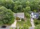 Aerial view of a beautiful home with a large front yard, mature trees, and a swimming pool in the backyard at 2001 Carrington Dr, Raleigh, NC 27615