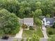 Aerial view showcasing a home with manicured lawn, mature trees, and nearby swimming pool at 2001 Carrington Dr, Raleigh, NC 27615