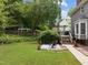 Spacious backyard with lush grass, mature trees, a wooden fence, and a stone patio at 2001 Carrington Dr, Raleigh, NC 27615