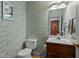 Cozy powder room with wood vanity and patterned wallpaper at 2001 Carrington Dr, Raleigh, NC 27615