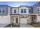 Charming two-story townhome featuring a stone facade, single-car garage, and inviting entryway at 2004 Regal Dr # 86, Durham, NC 27703