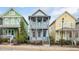 Charming two-story house with a inviting front porch and vibrant turquoise doors, nestled between colorful homes at 2098 Great Ridge Pkwy, Chapel Hill, NC 27516