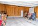 Unfinished garage with plywood walls and a concrete floor and a white door, piled with unpacked boxes at 2098 Great Ridge Pkwy, Chapel Hill, NC 27516