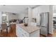 Open-concept kitchen with granite island, stainless steel fridge, and hardwood floors at 211 Candia Ln, Cary, NC 27519