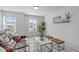 Sitting room with a dark brown leather sofa, coffee table, and two upholstered ottomans at 2534 Great Daisy Ln, New Hill, NC 27562