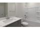 Bathroom with a single vanity, a mirror, a white toilet, and a combined shower and tub with white tile surround at 257 Umstead St, Sanford, NC 27330