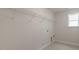 A bright laundry room with a window and white wire shelving rack over a light colored tile floor at 257 Umstead St, Sanford, NC 27330