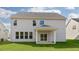 Back of house with covered patio overlooks expansive backyard with lush, green lawn at 273 Umstead St, Sanford, NC 27330