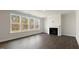 Sunlit living room with wood-look floors, a cozy fireplace, and large windows offering scenic outdoor views at 273 Umstead St, Sanford, NC 27330