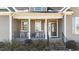 Inviting front porch features rocking chairs, brick steps and columns, creating a cozy entrance at 29 Alban Row, Fuquay Varina, NC 27526