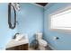 Charming powder room featuring a light blue paint, modern fixtures, and a window at 29 Alban Row, Fuquay Varina, NC 27526