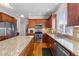 Modern kitchen with stainless steel appliances, granite countertops, a central island, and hardwood floors at 29 Alban Row, Fuquay Varina, NC 27526