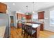 Open kitchen with a central island, stainless steel appliances, and hardwood floors at 29 Alban Row, Fuquay Varina, NC 27526