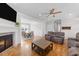 Open-concept living room with hardwood floors, a fireplace, and a view of the dining area at 29 Alban Row, Fuquay Varina, NC 27526