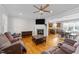 Cozy living room features hardwood floors, a fireplace, ceiling fan, and open access to the kitchen at 29 Alban Row, Fuquay Varina, NC 27526