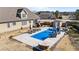 Aerial view of the backyard showcasing a pool with slide, surrounding patio space with seating, and well-maintained landscaping at 29 Alban Row, Fuquay Varina, NC 27526