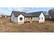 Rear view of the white farmhouse showcasing wood deck and black trim at 2955 Mt Pleasant Rd, Willow Springs, NC 27592