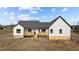 Rear view of the white farmhouse showcasing wood deck and black trim at 2955 Mt Pleasant Rd, Willow Springs, NC 27592