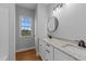 Bathroom features a double vanity with granite countertops, round mirrors, and wood floors at 2955 Mt Pleasant Rd, Willow Springs, NC 27592