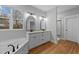 A bathroom features a bathtub, double vanity with granite countertops, hardwood floors, and a window at 2955 Mt Pleasant Rd, Willow Springs, NC 27592