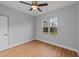 A well-lit bedroom features hardwood floors, neutral walls, and a ceiling fan with a window overlooking the outdoors at 2955 Mt Pleasant Rd, Willow Springs, NC 27592