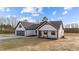 A modern white farmhouse-style home with dark trim, gray roof, and freshly laid concrete driveway at 2955 Mt Pleasant Rd, Willow Springs, NC 27592