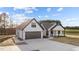 A modern white farmhouse-style home with dark trim, gray roof, and large concrete driveway at 2955 Mt Pleasant Rd, Willow Springs, NC 27592