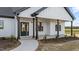 Close-up of front porch with dark pillars and a black-framed glass door, and a concrete walkway at 2955 Mt Pleasant Rd, Willow Springs, NC 27592