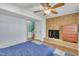 Basement bedroom showcasing a brick fireplace, ceiling fan, and neutral blue paint at 3108 Selkirk Pl, Raleigh, NC 27604