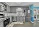 Well-lit kitchen featuring stainless steel appliances, gray cabinets, and a subway tile backsplash at 3108 Selkirk Pl, Raleigh, NC 27604