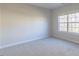 Bright bedroom featuring neutral walls, plush carpet, and a large window letting in natural light at 3671 Coach Lantern Ave, Wake Forest, NC 27587