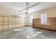 Spacious garage with concrete flooring, an automatic door opener, wooden shelves and two windows at 3671 Coach Lantern Ave, Wake Forest, NC 27587