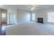 Spacious living room features plush carpet, a fireplace, and abundant natural light from large windows at 3671 Coach Lantern Ave, Wake Forest, NC 27587