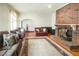 Spacious living room featuring hardwood floors, comfortable seating, and a striking brick fireplace at 41 E T Hanner Rd, Bear Creek, NC 27207