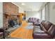 Cozy living room featuring hardwood floors, comfortable seating, and a striking brick fireplace at 41 E T Hanner Rd, Bear Creek, NC 27207