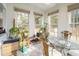 Bright sunroom with large windows, tile flooring, and a glass-top table perfect for plants at 41 E T Hanner Rd, Bear Creek, NC 27207