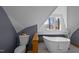 Attic bathroom with a modern tub, toilet, and charming window at 419 Obie Dr, Durham, NC 27713