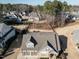 Aerial view showcasing a home with a large backyard, mature trees, and a glimpse of a nearby lake at 429 Teague St, Wake Forest, NC 27587