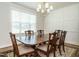 An elegant dining room featuring a large wooden table, classic chairs, and decorative wall paneling at 429 Teague St, Wake Forest, NC 27587