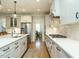 Bright kitchen featuring stainless steel appliances, white cabinets, and a long island with a sink at 429 Teague St, Wake Forest, NC 27587