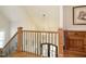 Elegant staircase features wrought iron spindles, wood railing and treads with a decorative hanging light fixture at 429 Teague St, Wake Forest, NC 27587