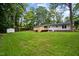 Picturesque backyard with a large grassy area, mature trees, and a white shed at 4705 Bernie Pl, Raleigh, NC 27616