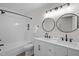 Modern bathroom featuring double sinks with a subway-tiled shower and matte black hardware at 4705 Bernie Pl, Raleigh, NC 27616